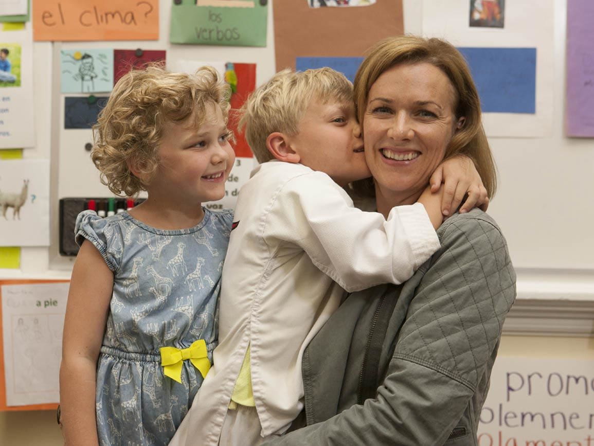 Preschool siblings kissing mom