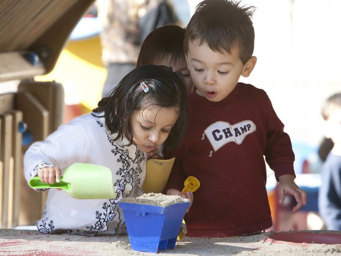 Two kids playing together with sand