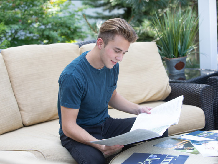 High school student reading through college brochures