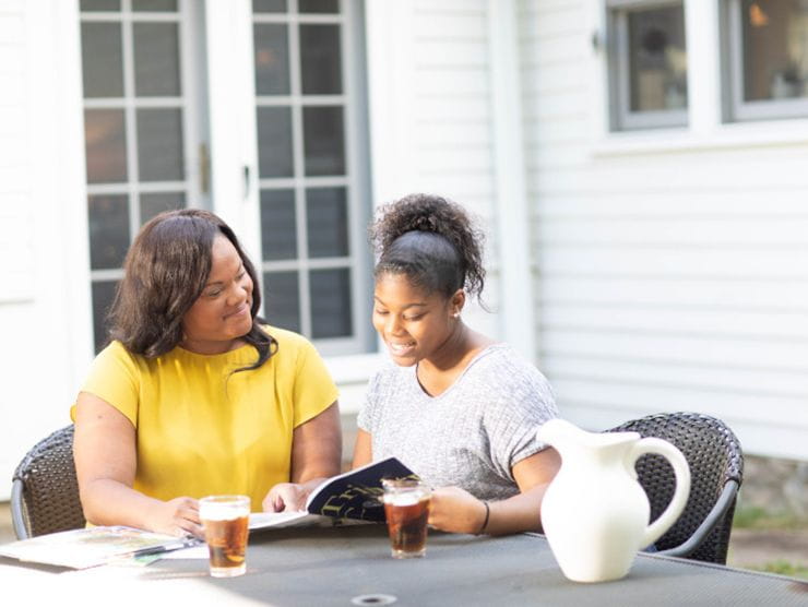 mom and daughter looking over book outside