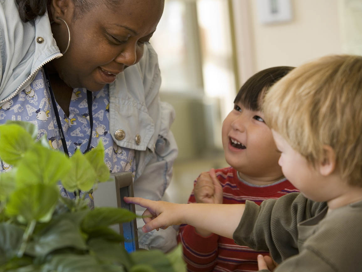 Teacher observing plants with two toddlers