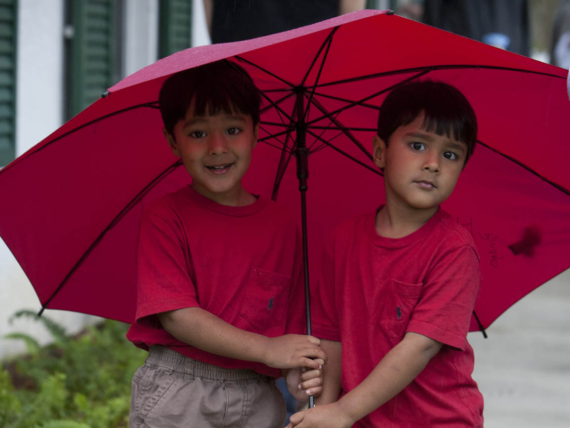 Twins under a red umbrella