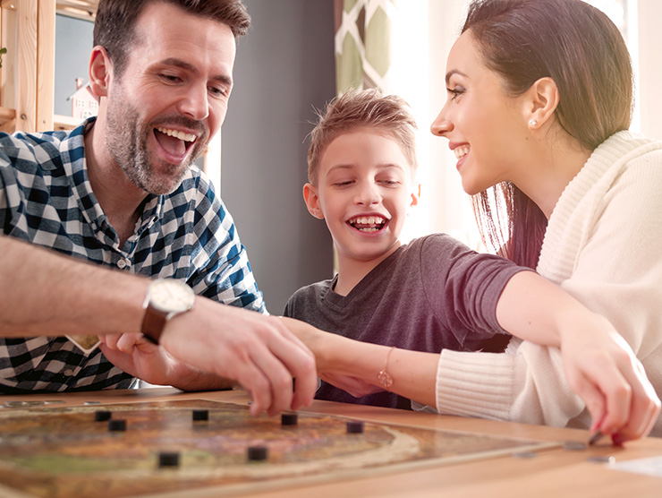 family gathered together playing board games and laughing 