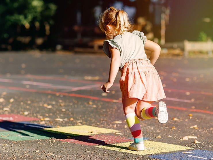 Little girl playing hopscotch outside at day care