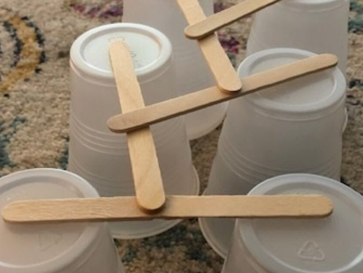 Cups and popsicle sticks turned into a bridge for at home crafts