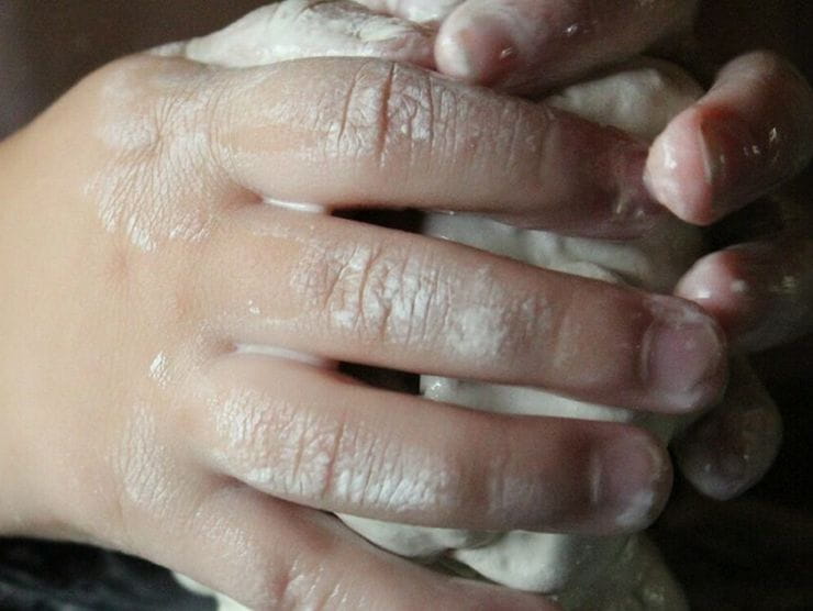 Toddlers hands molding and shaping clay at day care 