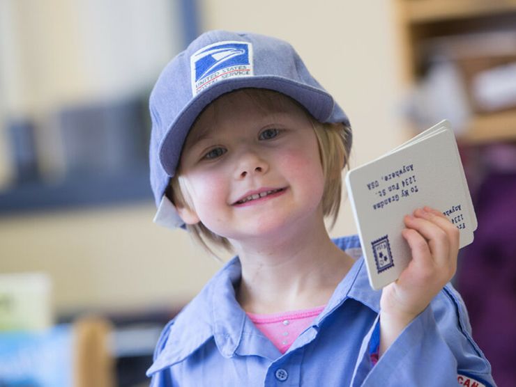 Preschooler dressing up as a postal worker at day care 