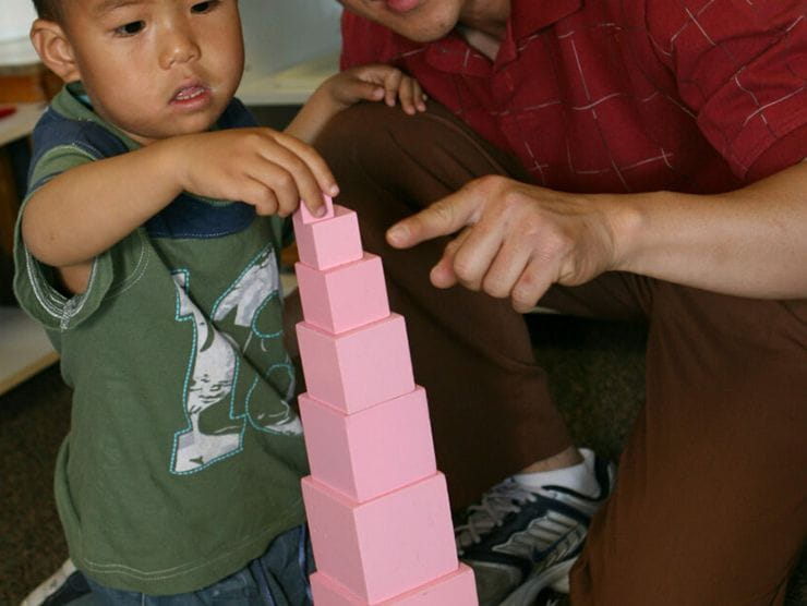 Toddler building a tower out of cups at day care 