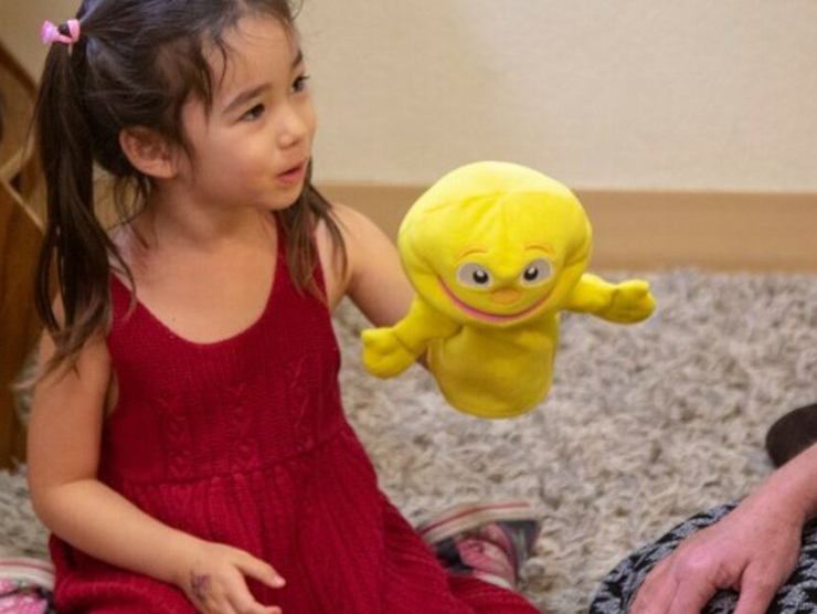Toddler using a puppet during playtime at day care 