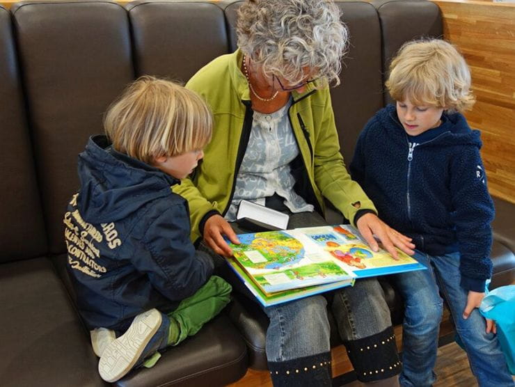 Adult interacting with children at day care by reading with them