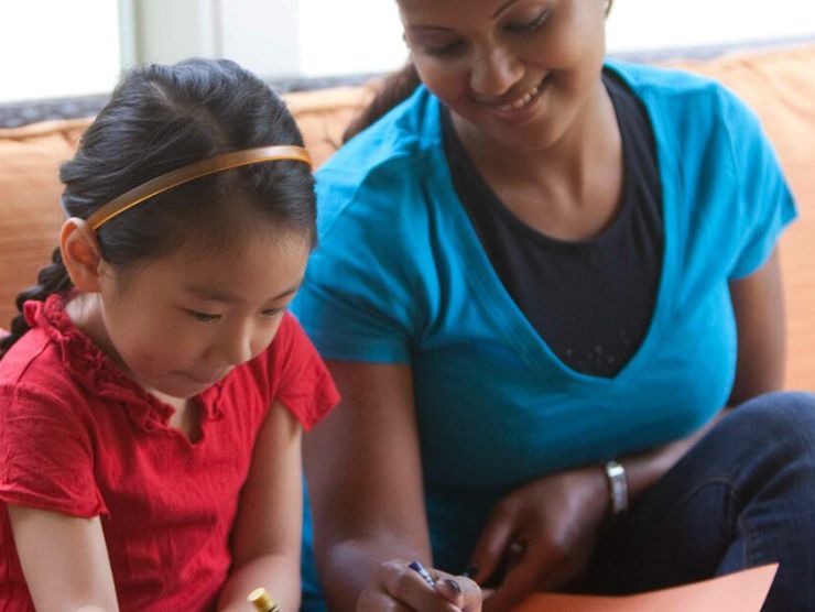 Mother and daughter at home making cards together 