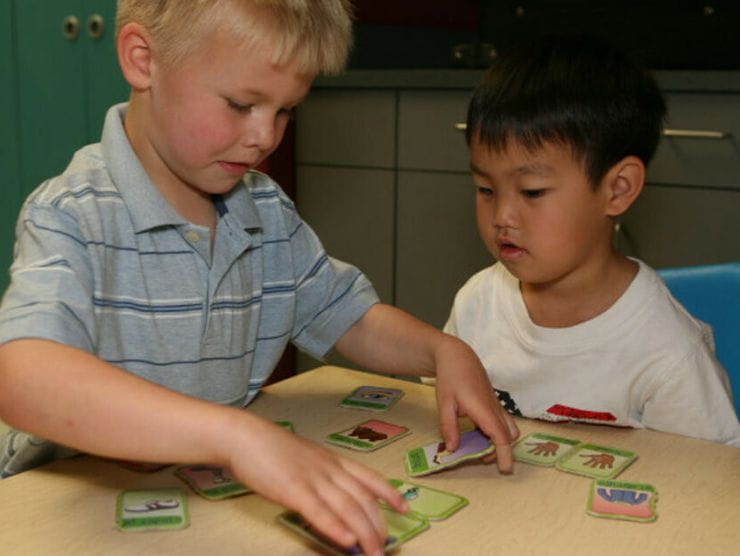 Two toddlers playing a matching card game at Bright Horizons day care 