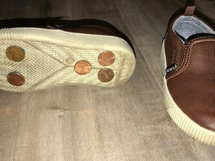 Kid size shoes on the floor with pennies glued on the bottom