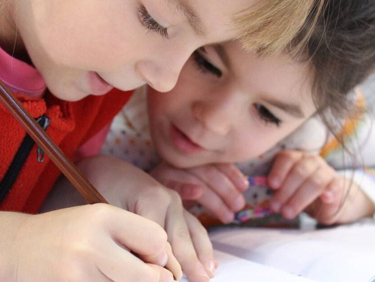 Two children learning to write in their classroom at day care  