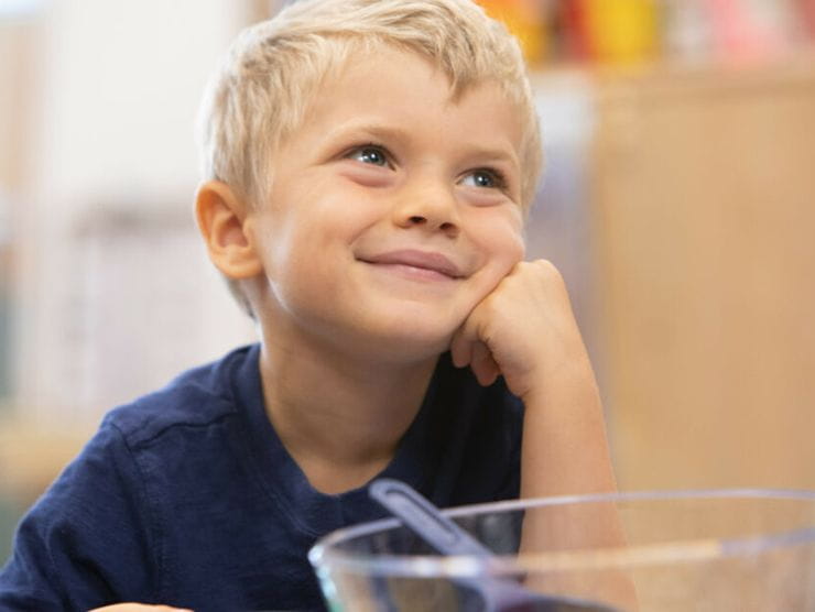 Toddler gazing up and smiling in his classroom at daycare 