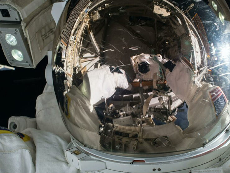 An astronaut in space with a reflective helmet on 