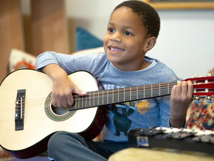 Young boy playing the guitar at day care 