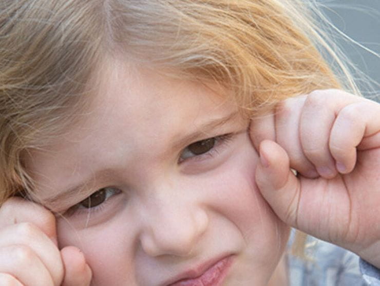 Toddler imitating a sad crying face 