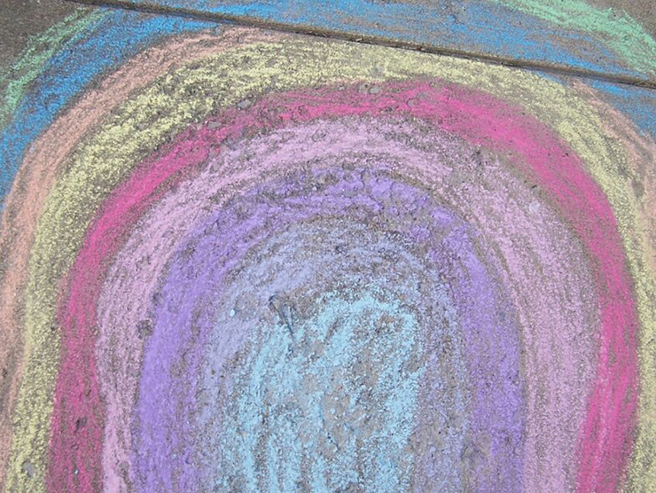 A rainbow drawn from chalk on the sidewalk 