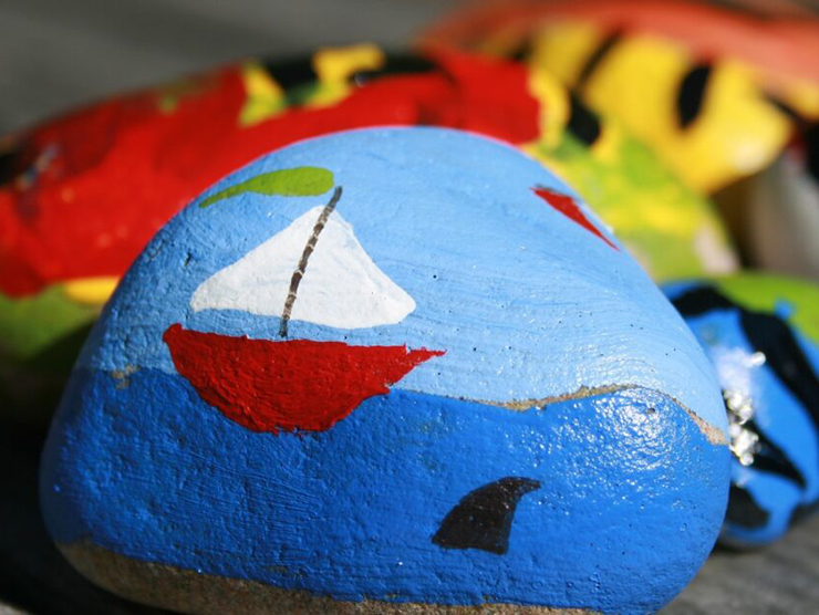 A rock with a painting of the ocean on it done at day care during arts and crafts 