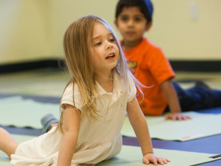 Kids preforming yoga poses at day care 