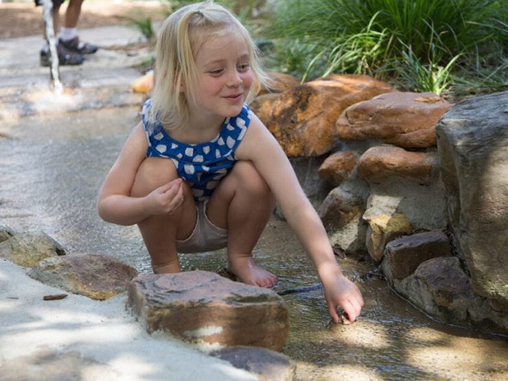 Preschooler playing in a stream outside in nature 