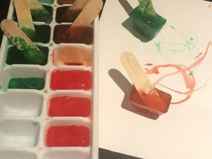 Colored ice cubes on popsicle sticks used for arts and crafts 
