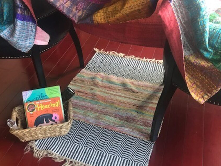 A fort made at home out of chairs and blankets