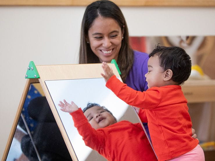 Teacher Helping Student Look Into Mirror