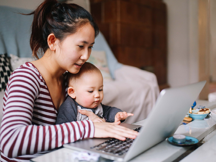 mom with infant looking at laptop