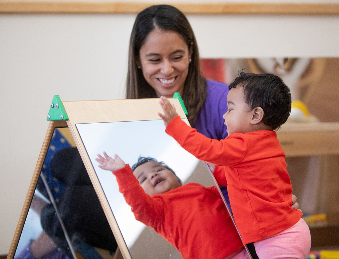 Young child playing with mirror