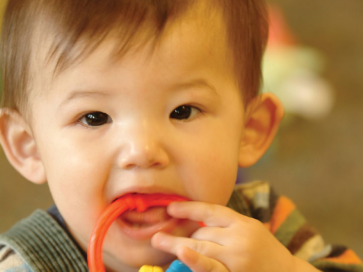 Toddler with toy in mouth