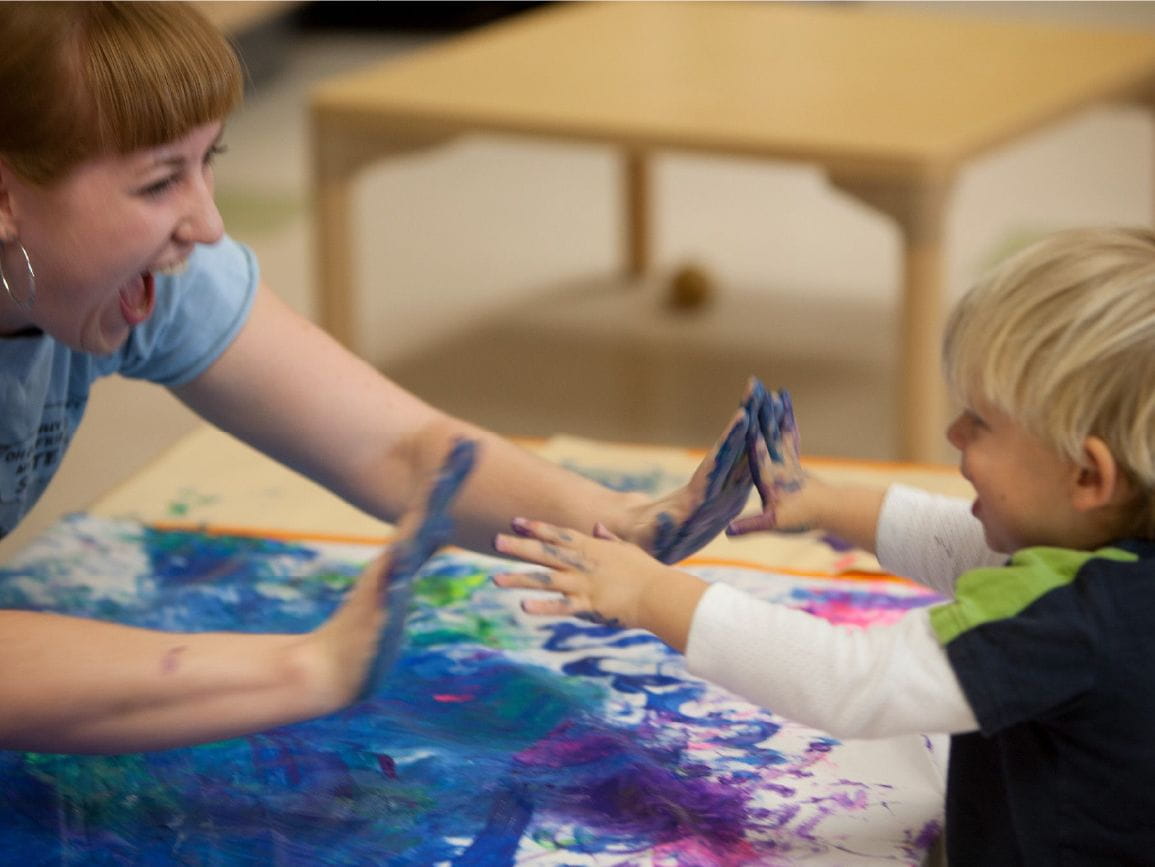 Child at center playing with paint