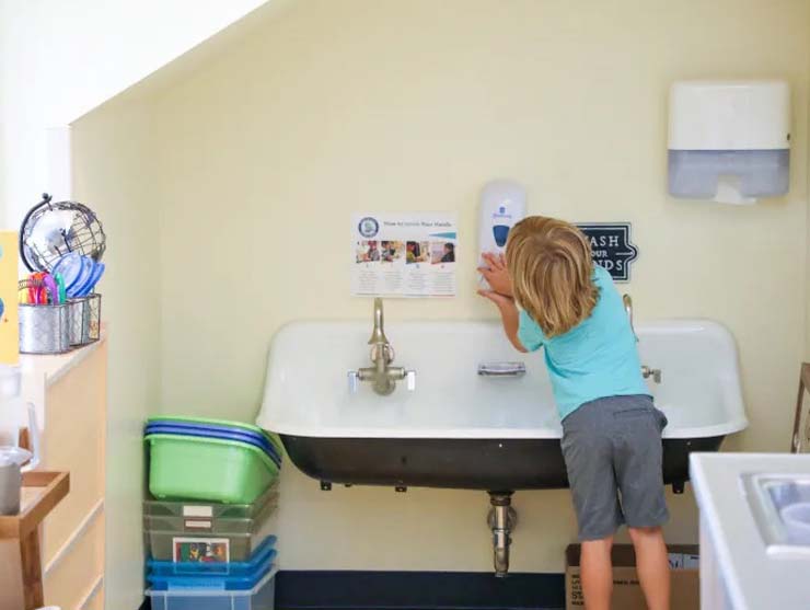 child washing hands in center