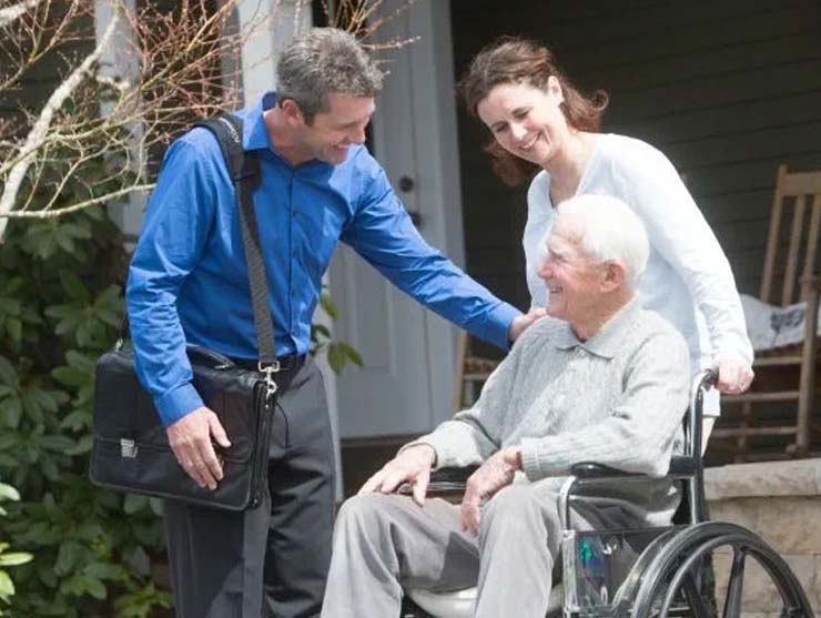 An older man in a wheelchair with his family