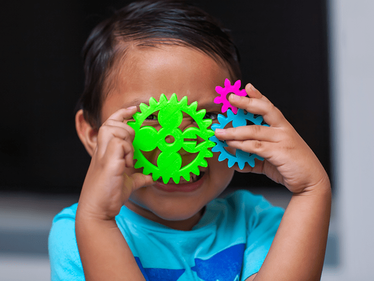 Child inspecting colored gears in a STEM class