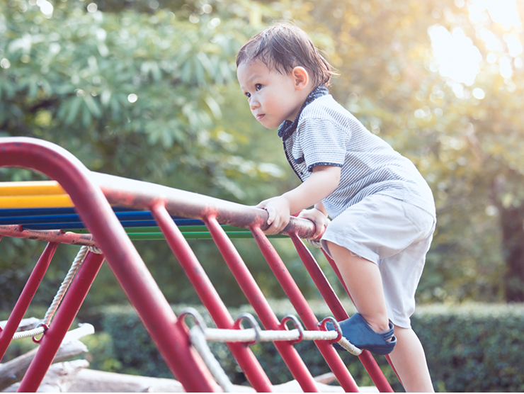 A child climbing a jungle gym at the playground ?? 