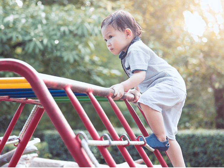 A child climbing a jungle gym at the playground