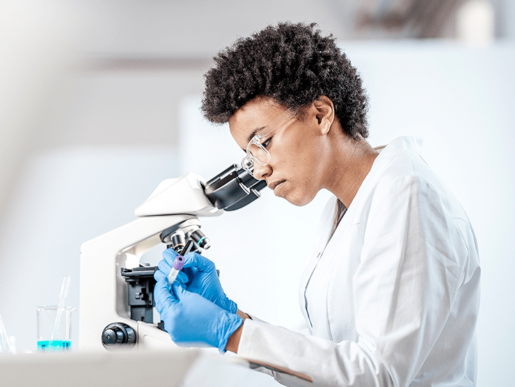 Black female scientist inspecting her work