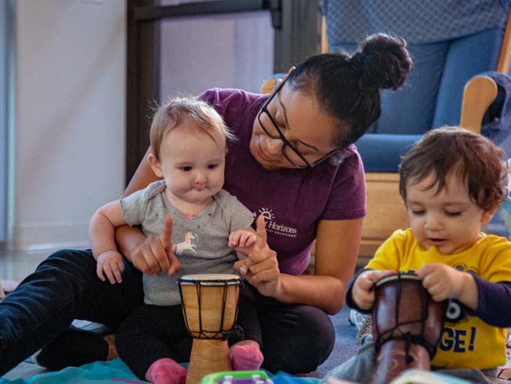 Teacher and infant playing the drums