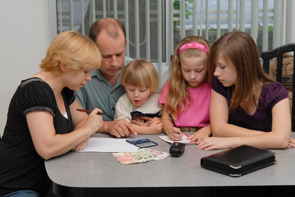 family teaching money skills and financial literacy to kids