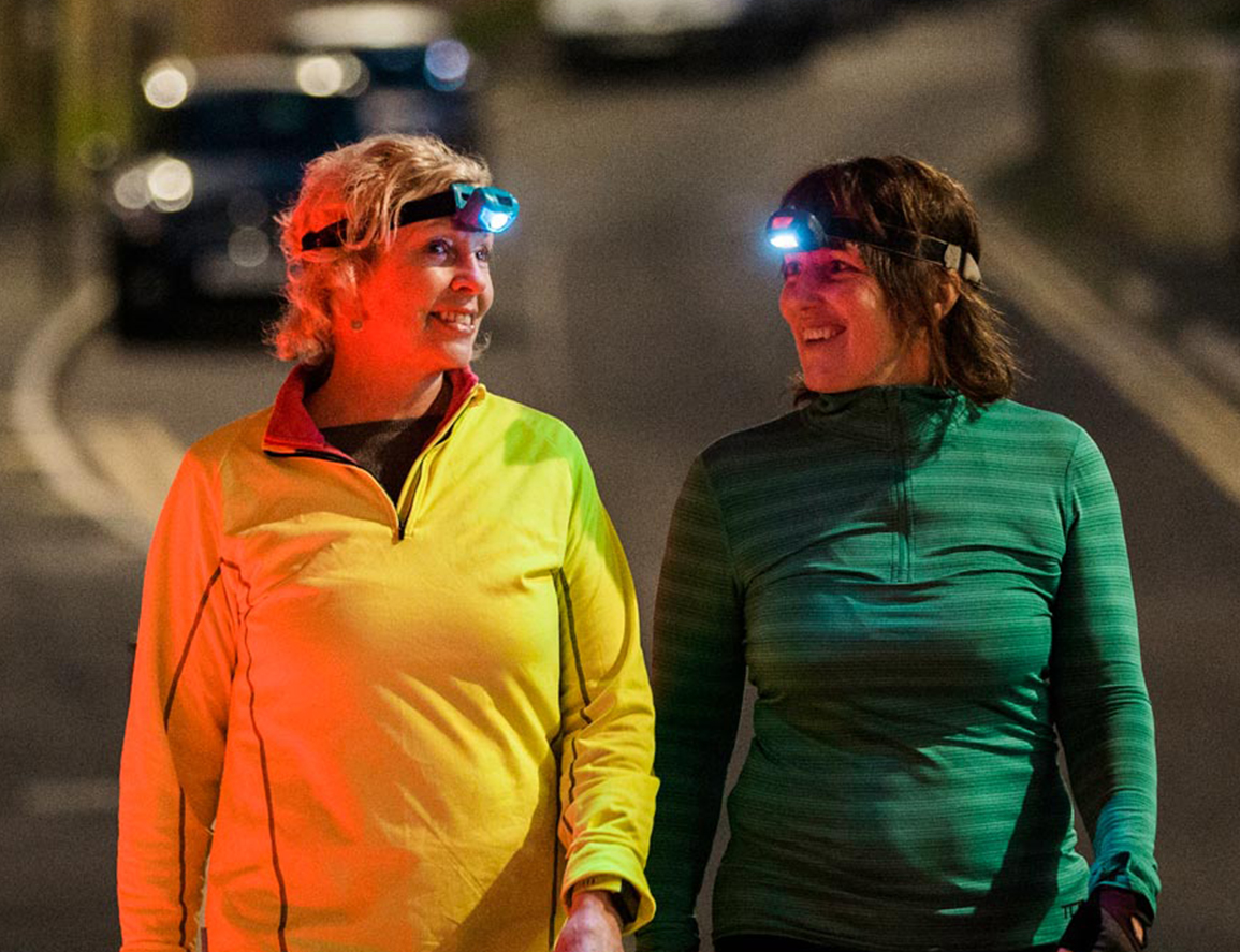 pair of working parents wearing headlamps for a night time walk