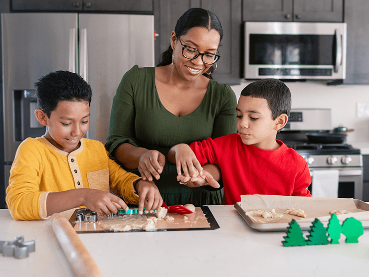 A woman and children making a gingerbread house