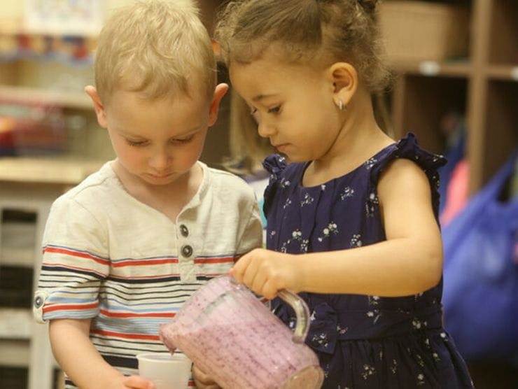 Two kids collaborating on a healthy cooking project at daycare