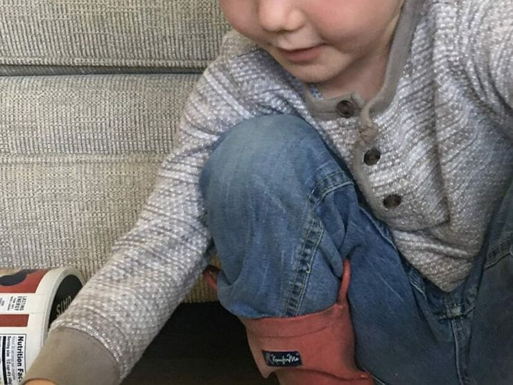 Toddler bending down to play with toys at home 