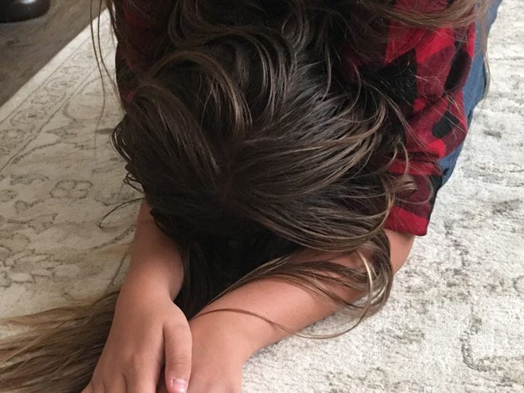 Young girl preforming a pretzel yoga pose at home 