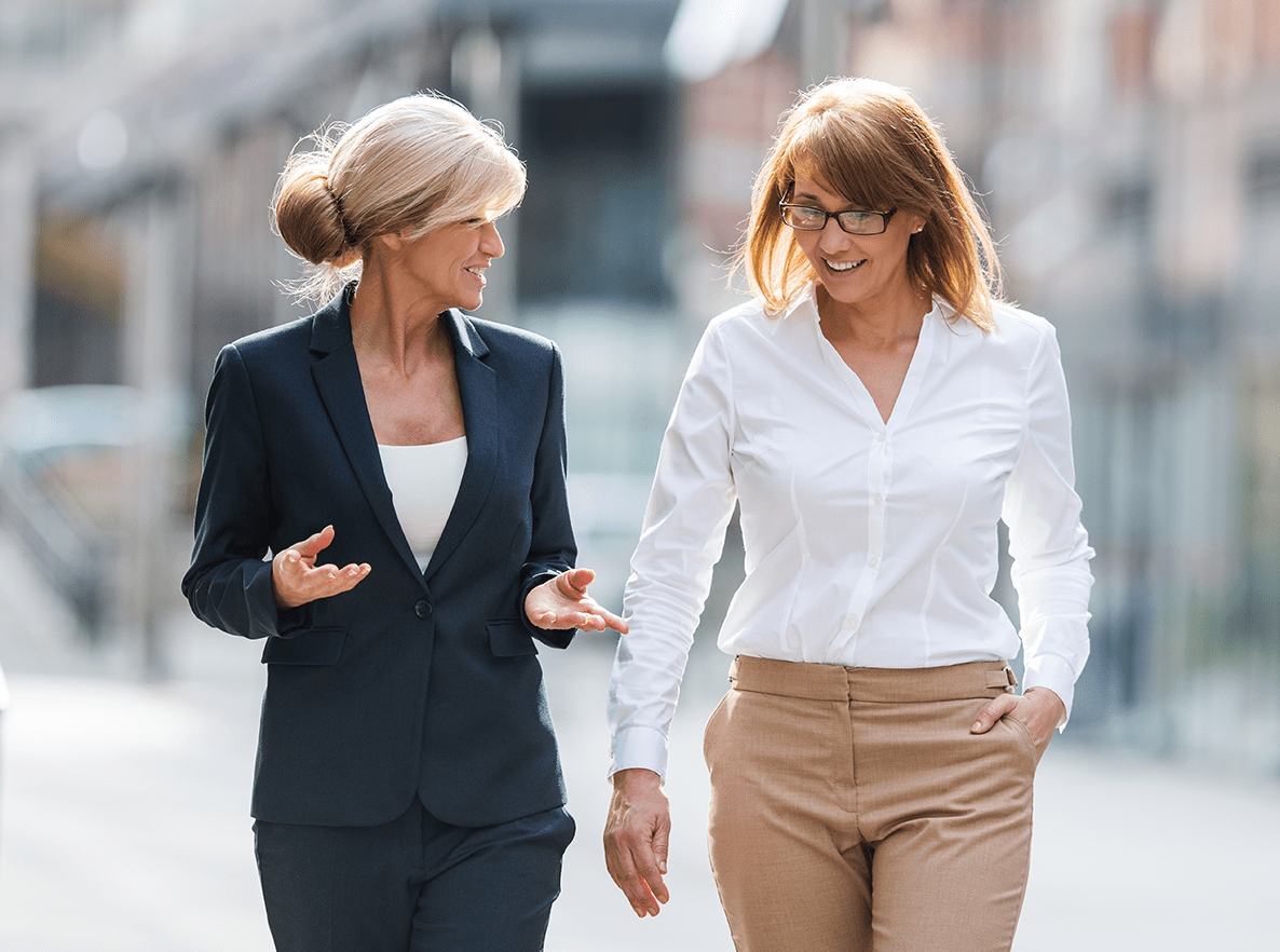 two professional women talking in street walking