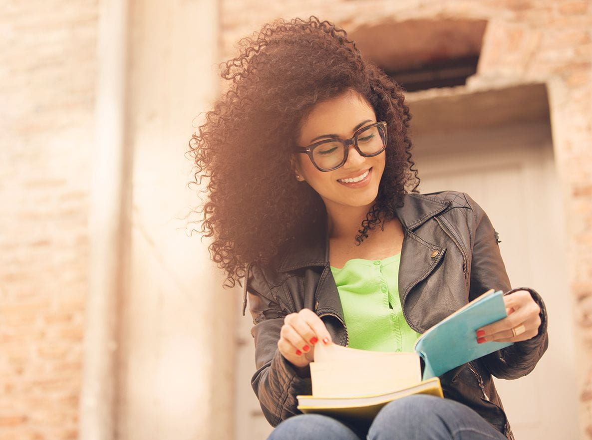 woman reading notes outside smiling