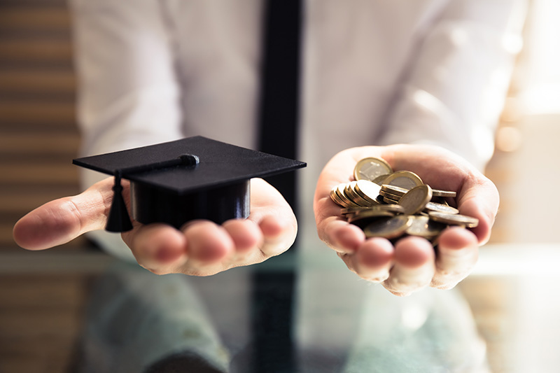 Two extended hands, one with a graduation cap and one with coins