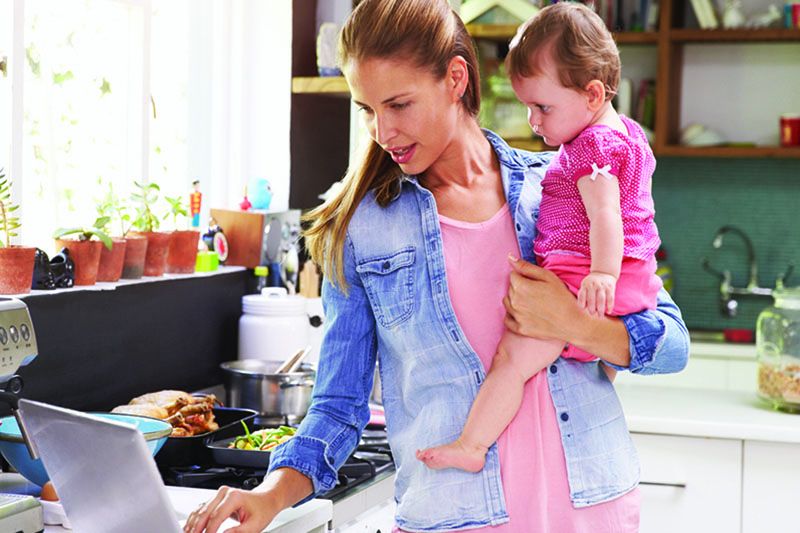 A mom working and holding her baby